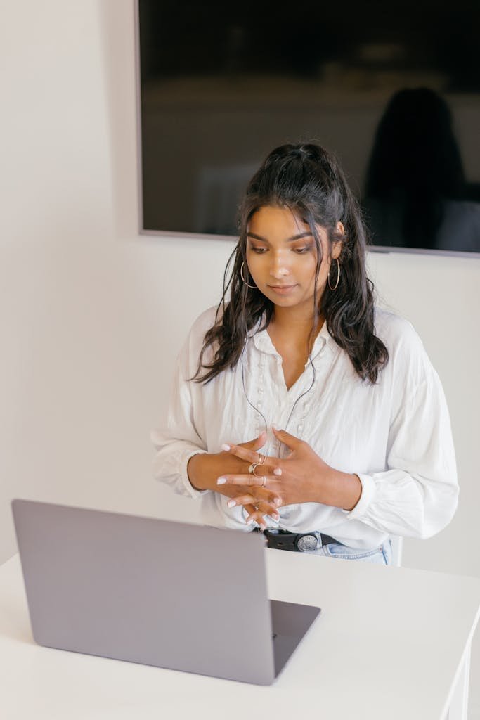 Woman using a laptop for e-learning, showing active online study engagement indoors.